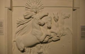 Ein Relief zeigt den Sonnengott Helios, ausgestattet mit Heiligenschein und Mantel, reitet auf vier Pferden